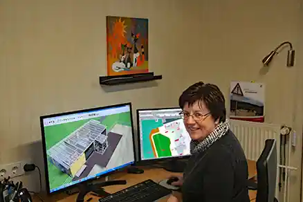 Kontaktpersoner 5 Bilden visar en kvinna som ses bakifrån och vänder sig om över axeln mot kameran. Hon sitter vid en datorarbetsplats.